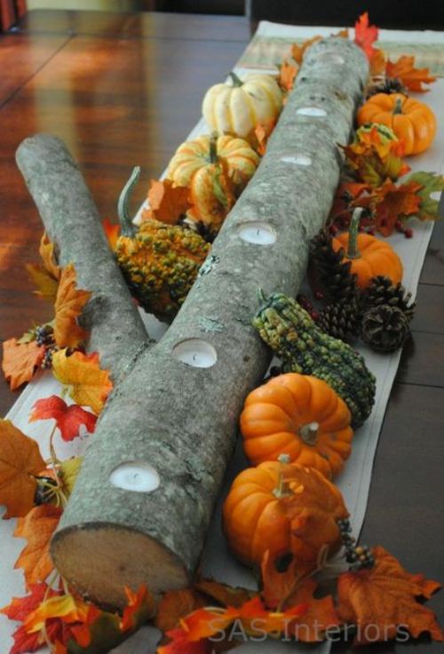 Simplicity at its best: Nature, harvest, and candles come together with a log with holes drilled for candles and accented with leaves, gourds, and mini pumpkins. Image courtesy of The Berry and SAS Interiors.